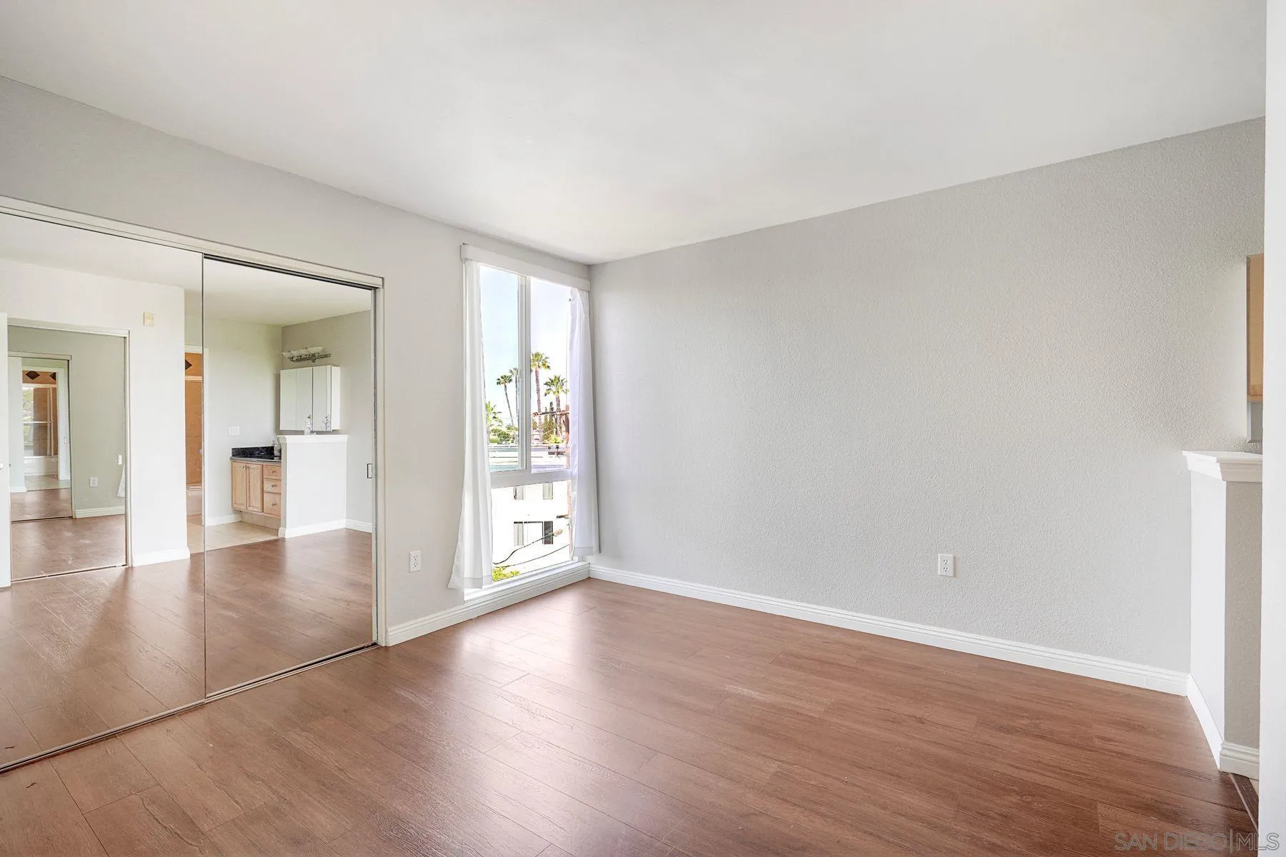 4860 Rolando Court, Unit 75 San Diego, CA 92115 - Photo 10 of 20 wooden floor in an empty room with a window