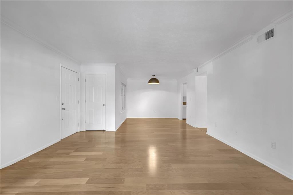a view of empty room with wooden floor