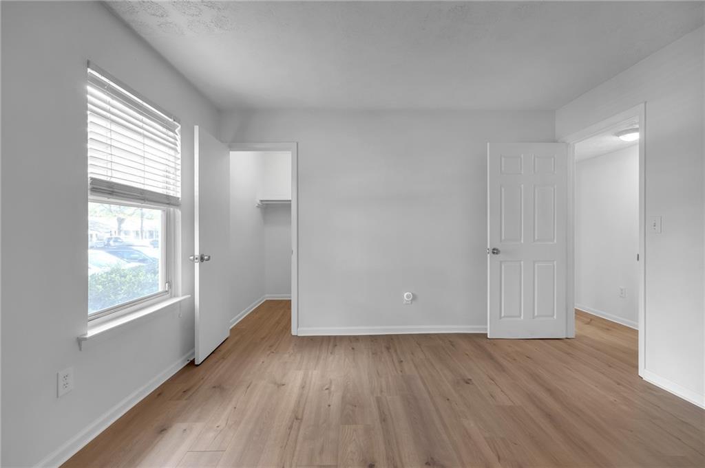1150 Collier Road Northwest, Unit 2J Atlanta, GA 30318 - Photo 14 of 41 an empty room with wooden floor and windows
