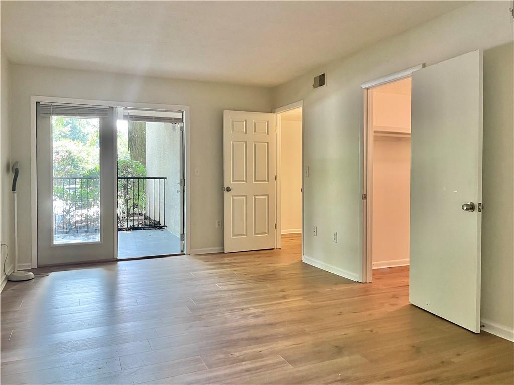 1150 Collier Road Northwest, Unit 2J Atlanta, GA 30318 - Photo 17 of 33 an empty room with wooden floor and windows