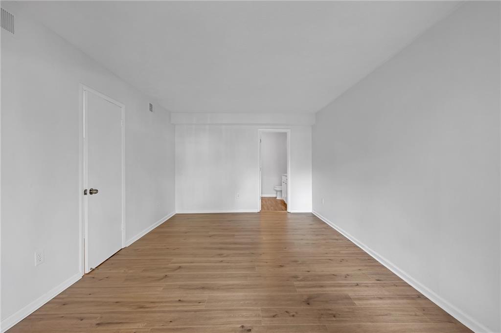 1150 Collier Road Northwest, Unit 2J Atlanta, GA 30318 - Photo 17 of 41 a view of an empty room and wooden floor