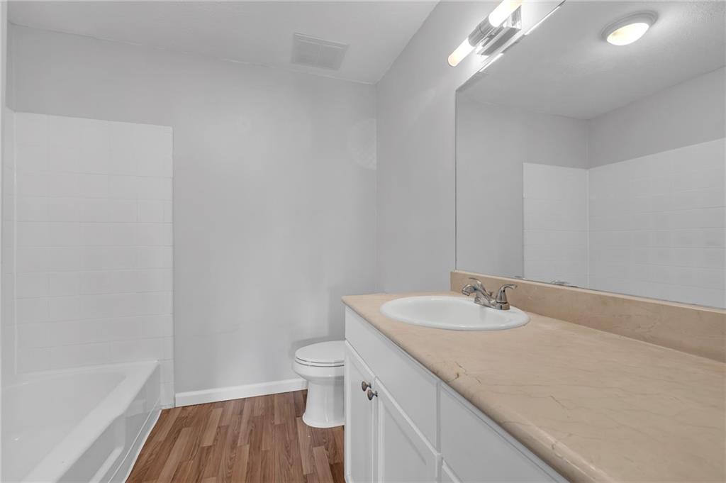 1150 Collier Road Northwest, Unit 2J Atlanta, GA 30318 - Photo 18 of 41 a bathroom with a granite countertop sink a toilet and a bathtub