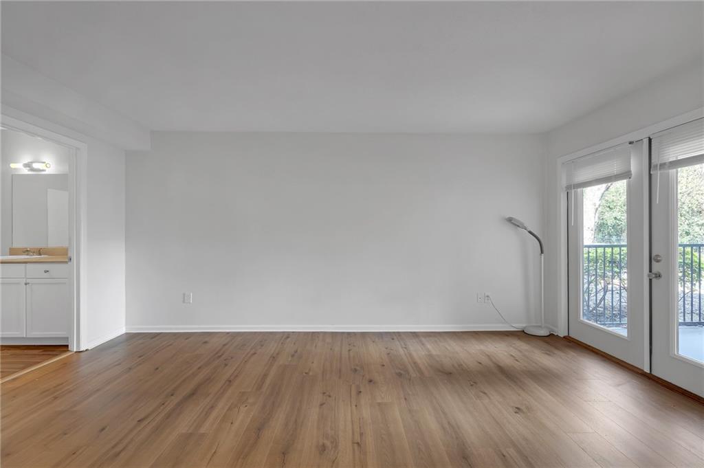 1150 Collier Road Northwest, Unit 2J Atlanta, GA 30318 - Photo 22 of 41 an empty room with wooden floor and windows