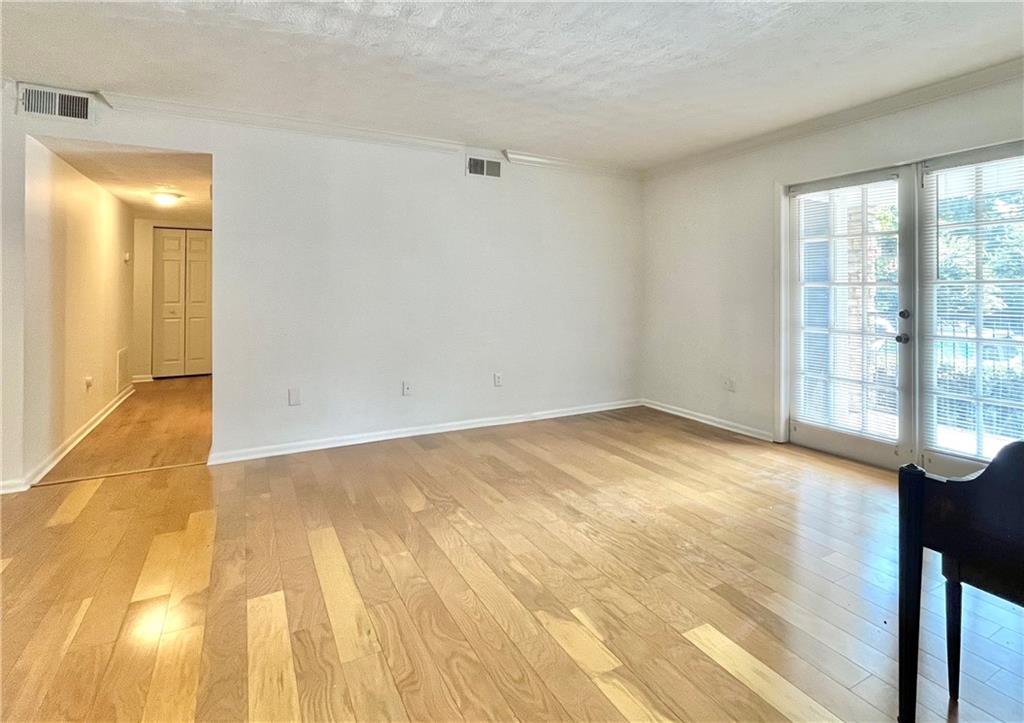 1150 Collier Road Northwest, Unit 2J Atlanta, GA 30318 - Photo 3 of 33 a view of empty room with wooden floor and fan