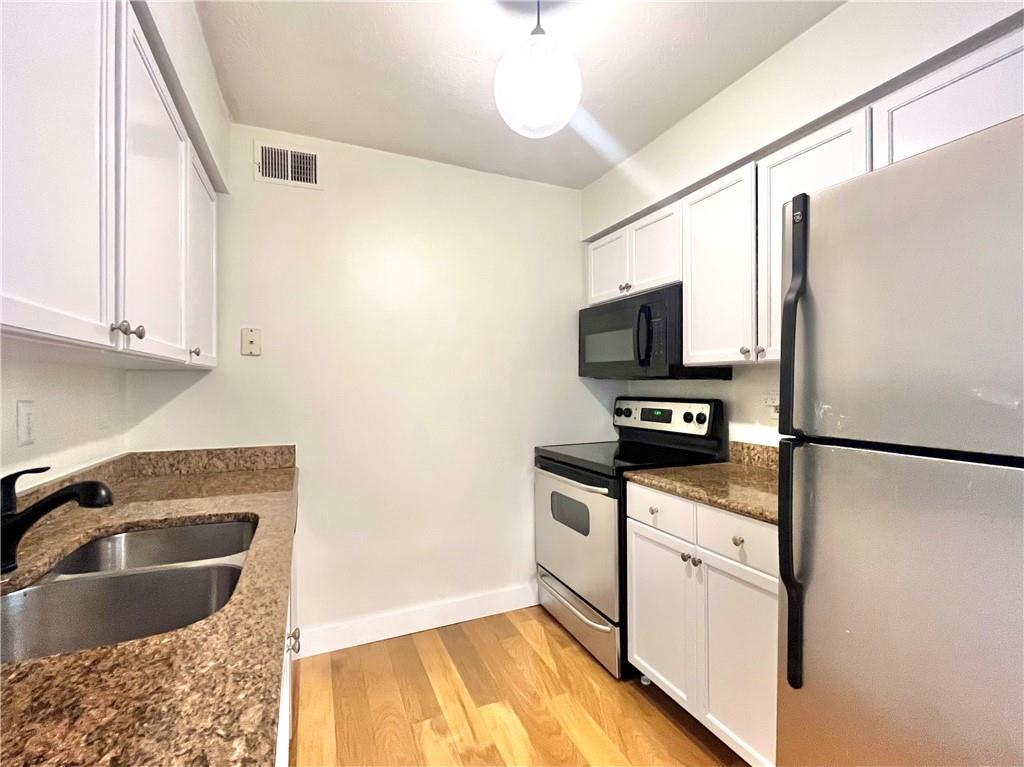 1150 Collier Road Northwest, Unit 2J Atlanta, GA 30318 - Photo 4 of 41 a kitchen with granite countertop a refrigerator stove and sink