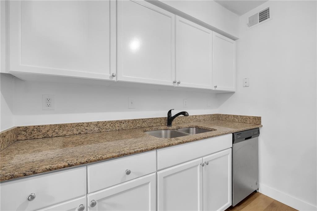1150 Collier Road Northwest, Unit 2J Atlanta, GA 30318 - Photo 5 of 41 a kitchen with granite countertop white cabinets and a sink