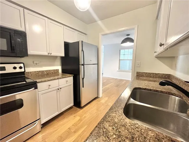 a kitchen with a sink cabinets and stainless steel appliances