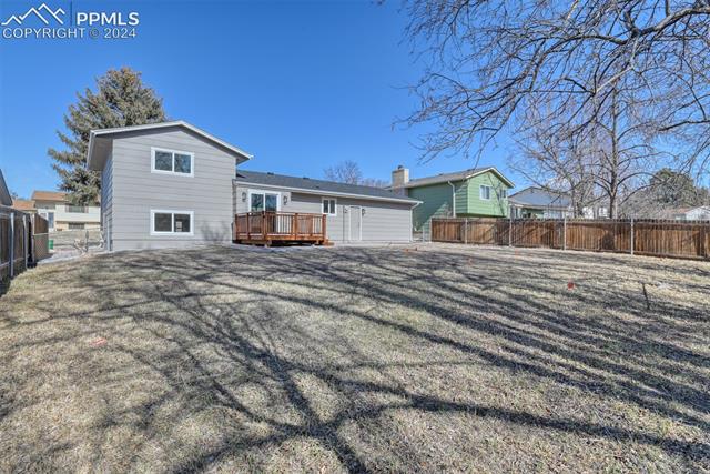 1913 Wooten Road Colorado Springs, CO 80915 - Photo 8 of 50 Back of property with a lawn and a deck