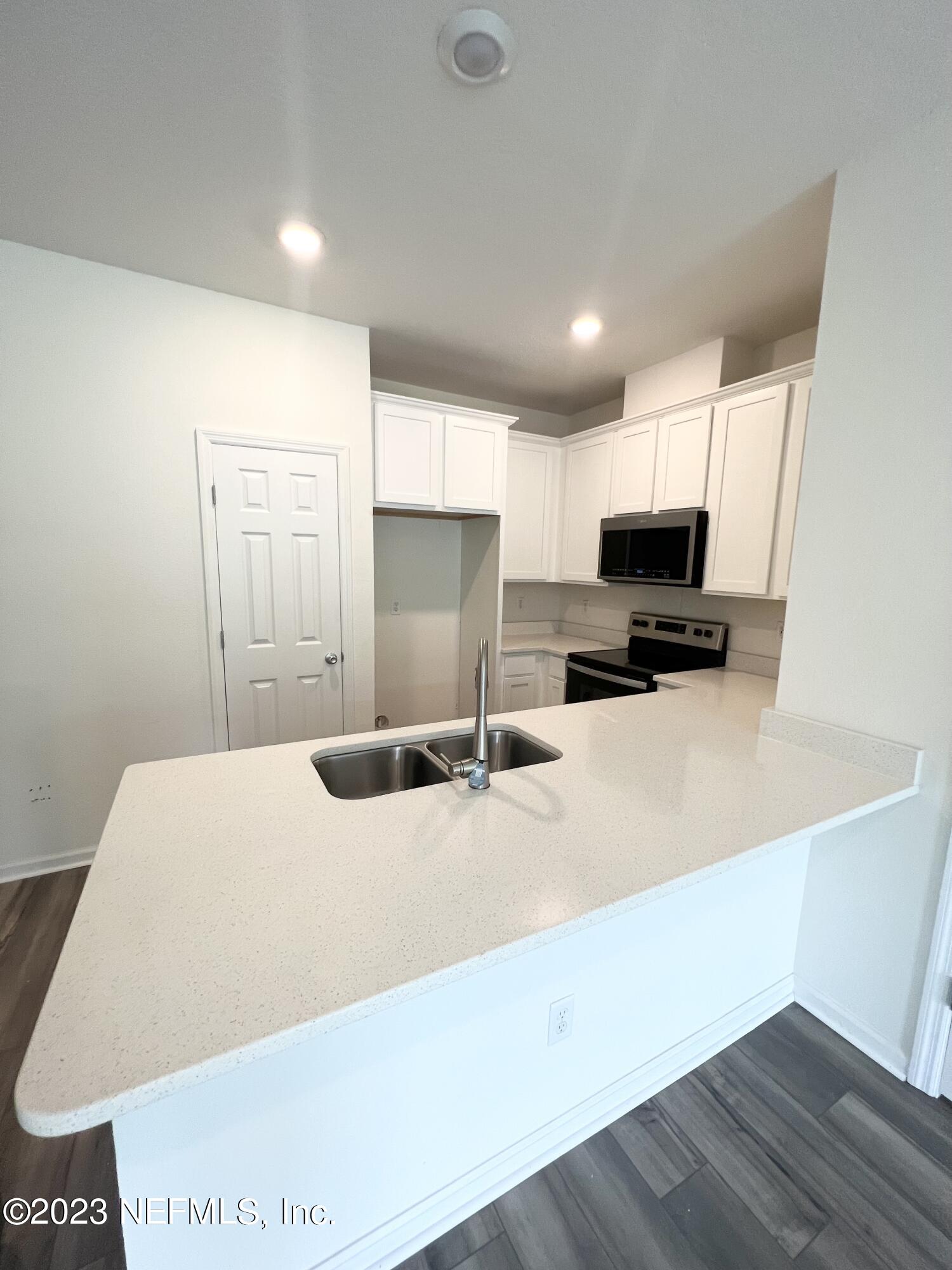 9883 Fiddleback Lane Jacksonville, FL 32222 - Photo 4 of 12 a kitchen with a sink a microwave and cabinets