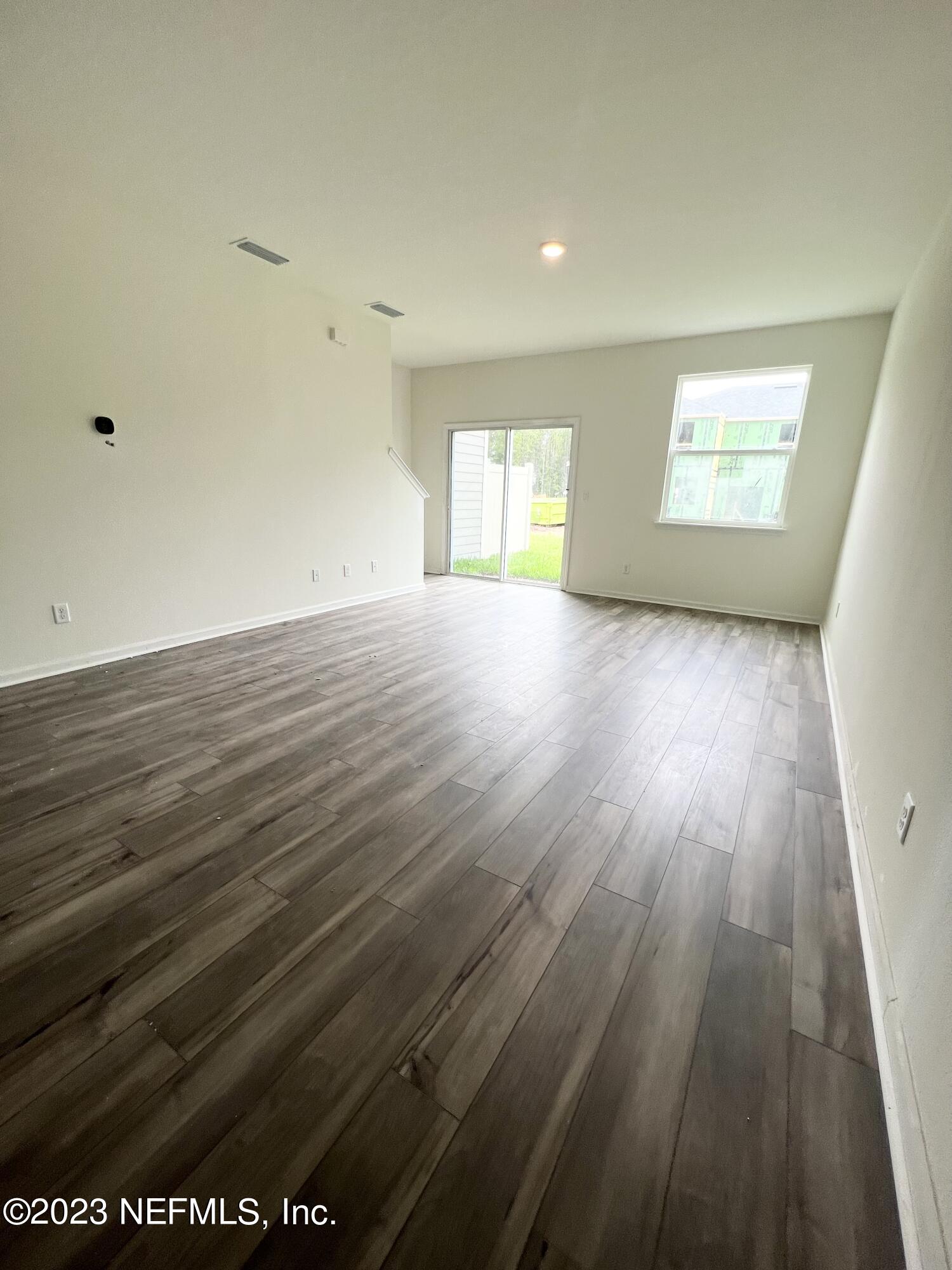 9883 Fiddleback Lane Jacksonville, FL 32222 - Photo 5 of 12 an empty room with wooden floor and windows