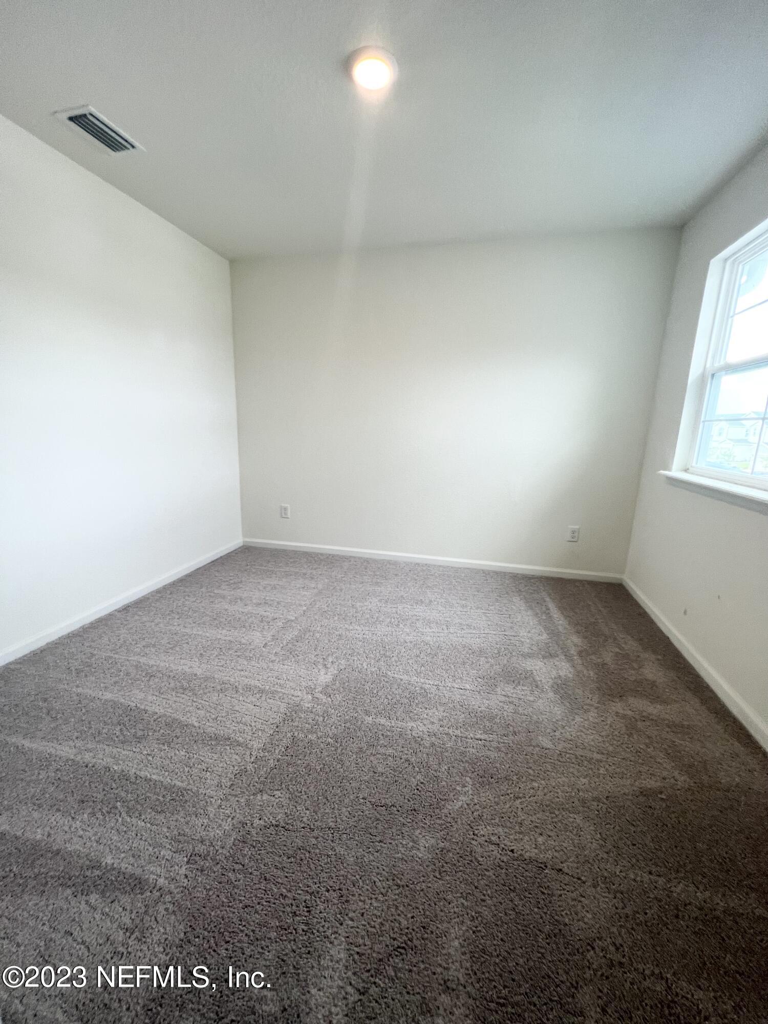 9883 Fiddleback Lane Jacksonville, FL 32222 - Photo 6 of 12 an empty room with windows
