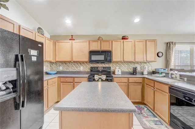 a kitchen with a table chairs refrigerator and a window