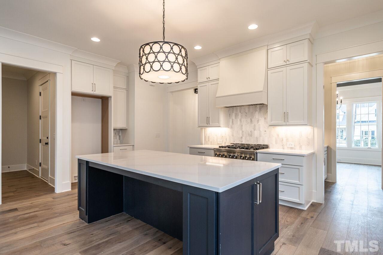 1104 Shelley Road Raleigh, NC 27609 - Photo 16 of 45 a kitchen with a stove chandelier and wooden floor