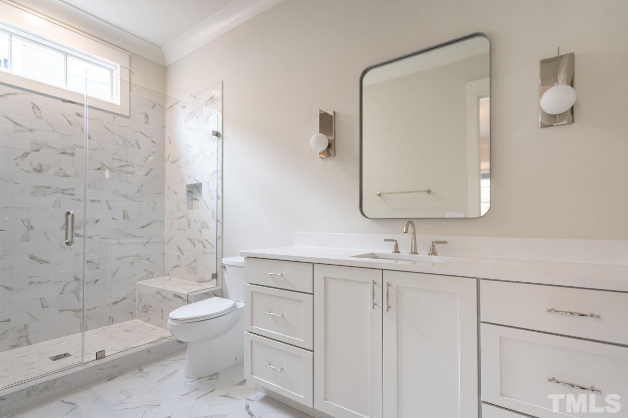 1104 Shelley Road Raleigh, NC 27609 - Photo 28 of 45 a bathroom with a double vanity sink toilet mirror and shower