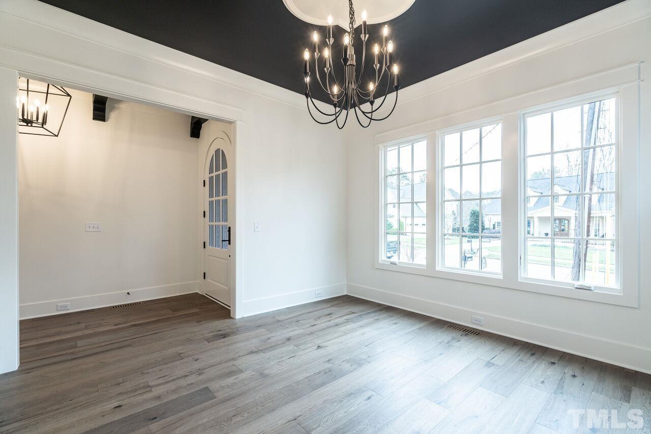 1104 Shelley Road Raleigh, NC 27609 - Photo 6 of 45 a view of an empty room with wooden floor and a window