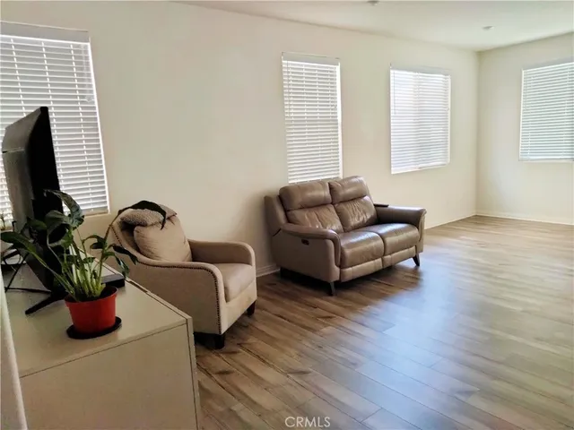 a living room with furniture a flat screen tv and a window