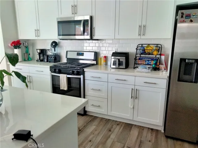 a kitchen with stainless steel appliances granite countertop a stove a sink and a refrigerator
