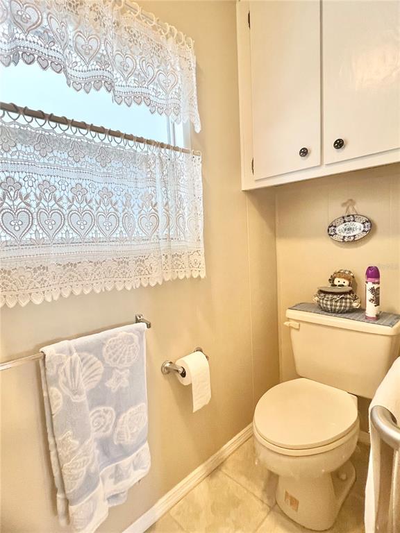 1100 South Belcher Road, Unit 197 Largo, FL 33771 - Photo 15 of 60 a white toilet sitting next to a white cabinet and a wooden floor