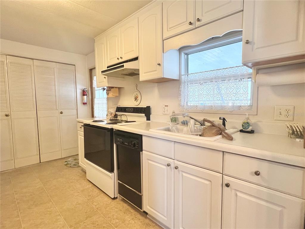 1100 South Belcher Road, Unit 197 Largo, FL 33771 - Photo 9 of 60 a kitchen with kitchen island granite countertop white cabinets sink and stainless steel appliances