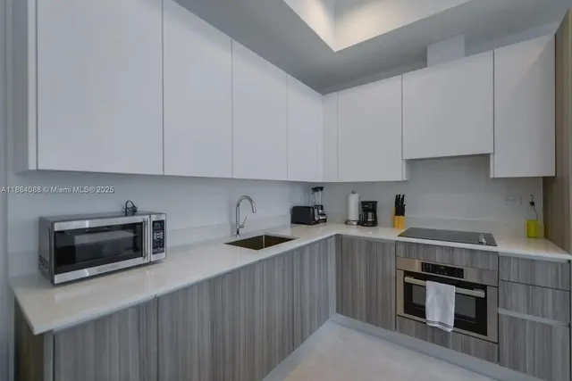 a kitchen with stainless steel appliances a stove a sink a microwave and cabinets