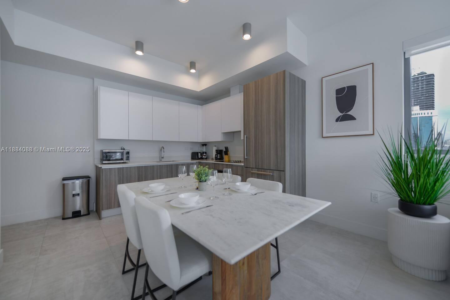 239 Southwest 9th Street, Unit 1601 Miami, FL 33130 - Photo 3 of 23 a kitchen with a table and chairs in it