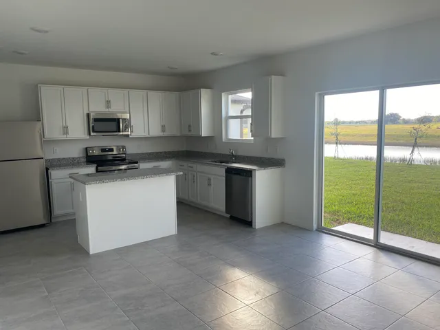 a kitchen with stainless steel appliances granite countertop a stove a sink and a microwave