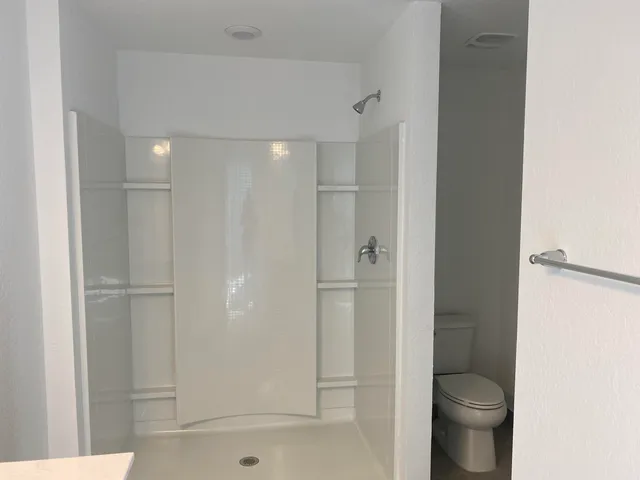 a bathroom with a shower and a toilet