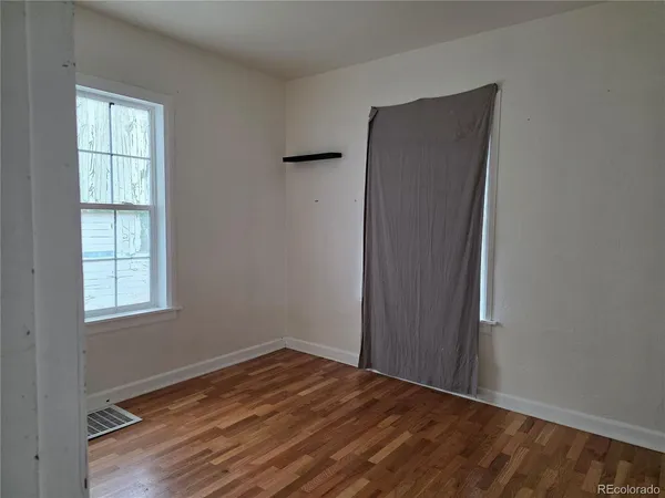 a view of a room with wooden floor and a window