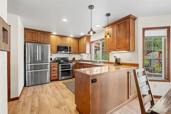 a kitchen with stainless steel appliances granite countertop a refrigerator and a stove top oven