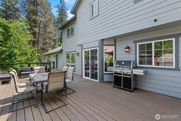 a view of a patio with table and chairs with wooden floor and fence