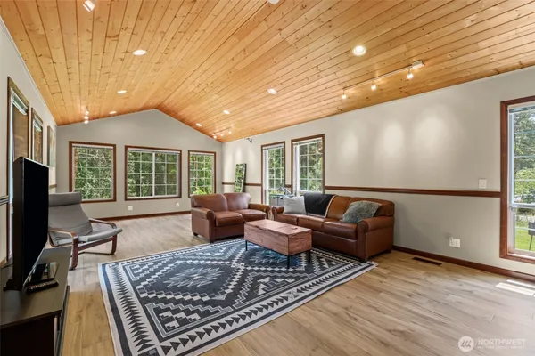 a living room with furniture hard wood floor and a rug