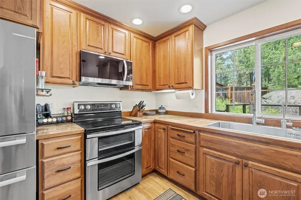 a kitchen with stainless steel appliances a stove sink and microwave