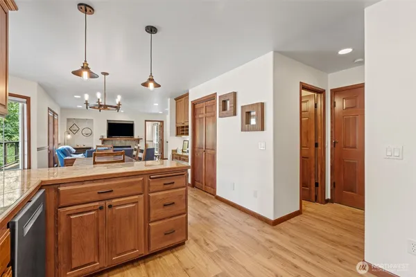 a kitchen with stainless steel appliances granite countertop a refrigerator a oven a sink dishwasher and white cabinets with wooden floor