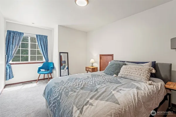 a bedroom with a bed a table and a window