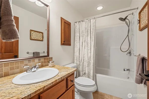 a bathroom with a granite countertop sink toilet and shower