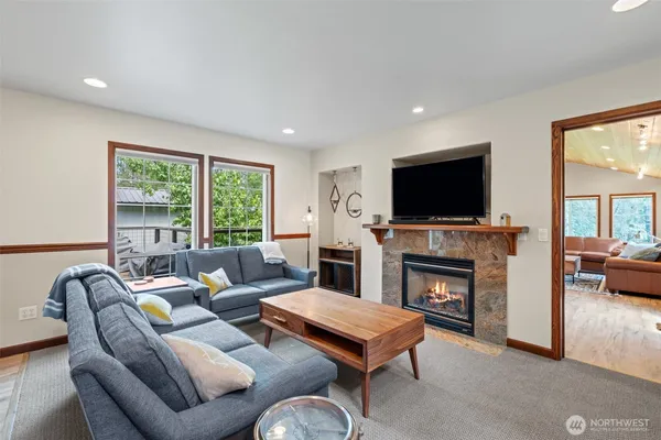 a living room with furniture a fireplace and a flat screen tv