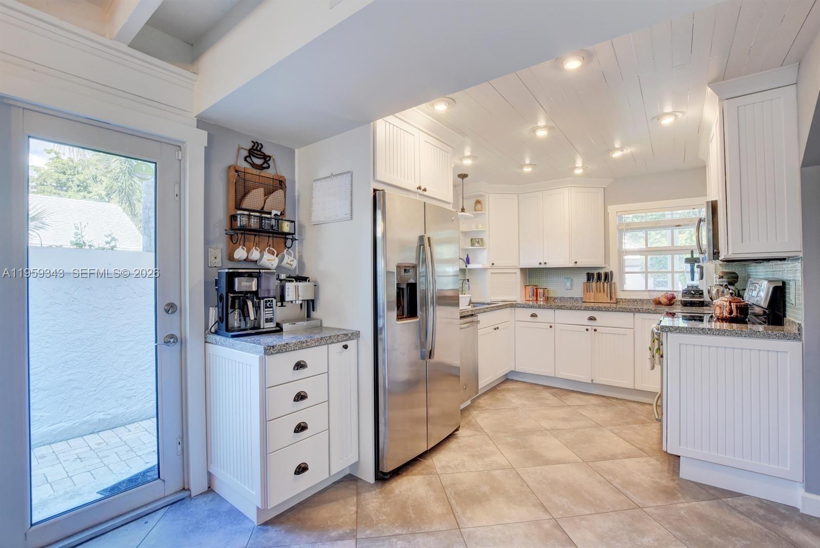1210 Southwest 19th Street Boca Raton, FL 33486 - Photo 13 of 43 a kitchen with white cabinets and white appliances
