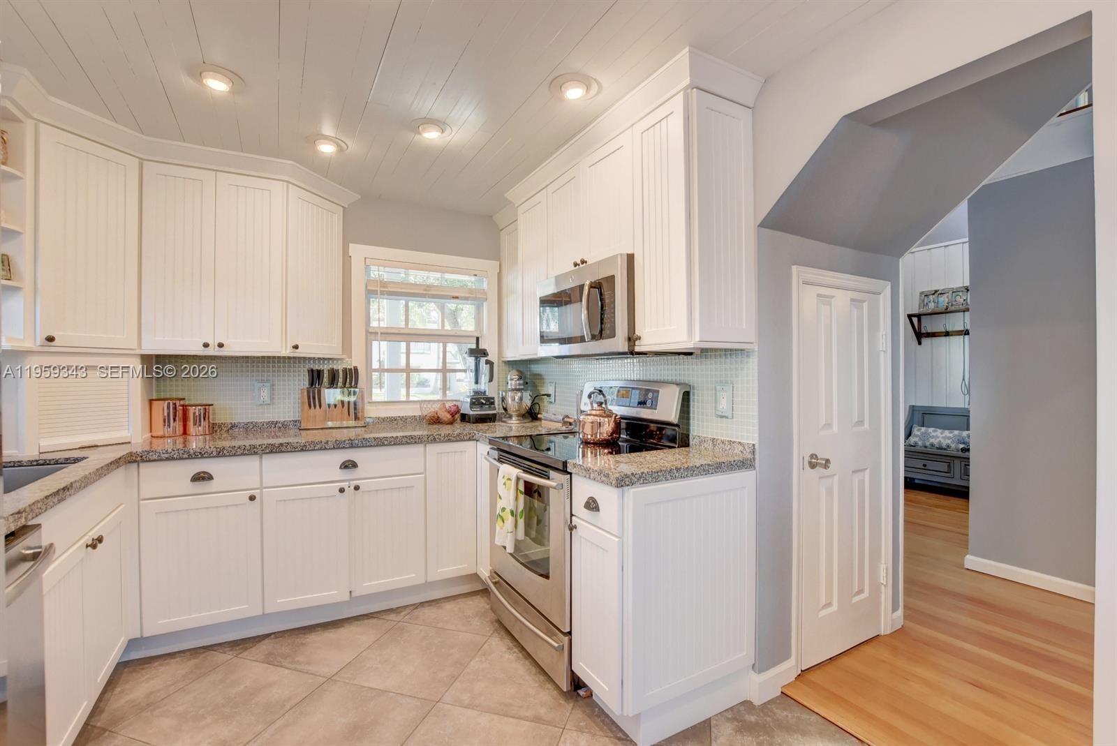 1210 Southwest 19th Street Boca Raton, FL 33486 - Photo 14 of 43 a kitchen with white cabinets stainless steel appliances and sink