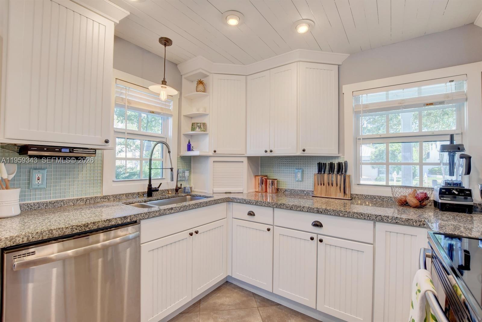 1210 Southwest 19th Street Boca Raton, FL 33486 - Photo 15 of 43 a kitchen with stainless steel appliances granite countertop a sink a stove and white cabinets