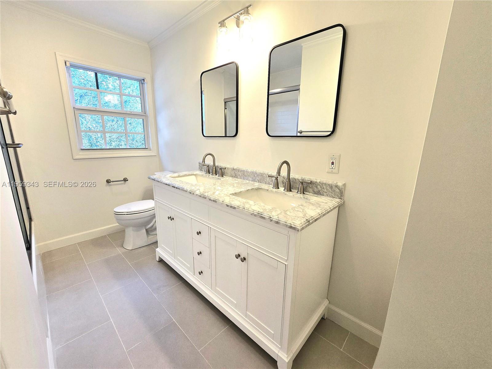 1210 Southwest 19th Street Boca Raton, FL 33486 - Photo 32 of 43 a bathroom with a double vanity sink toilet and mirror