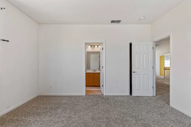 an empty room with closet and mirror
