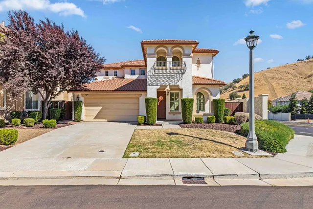 a front view of a building with a garden and plants