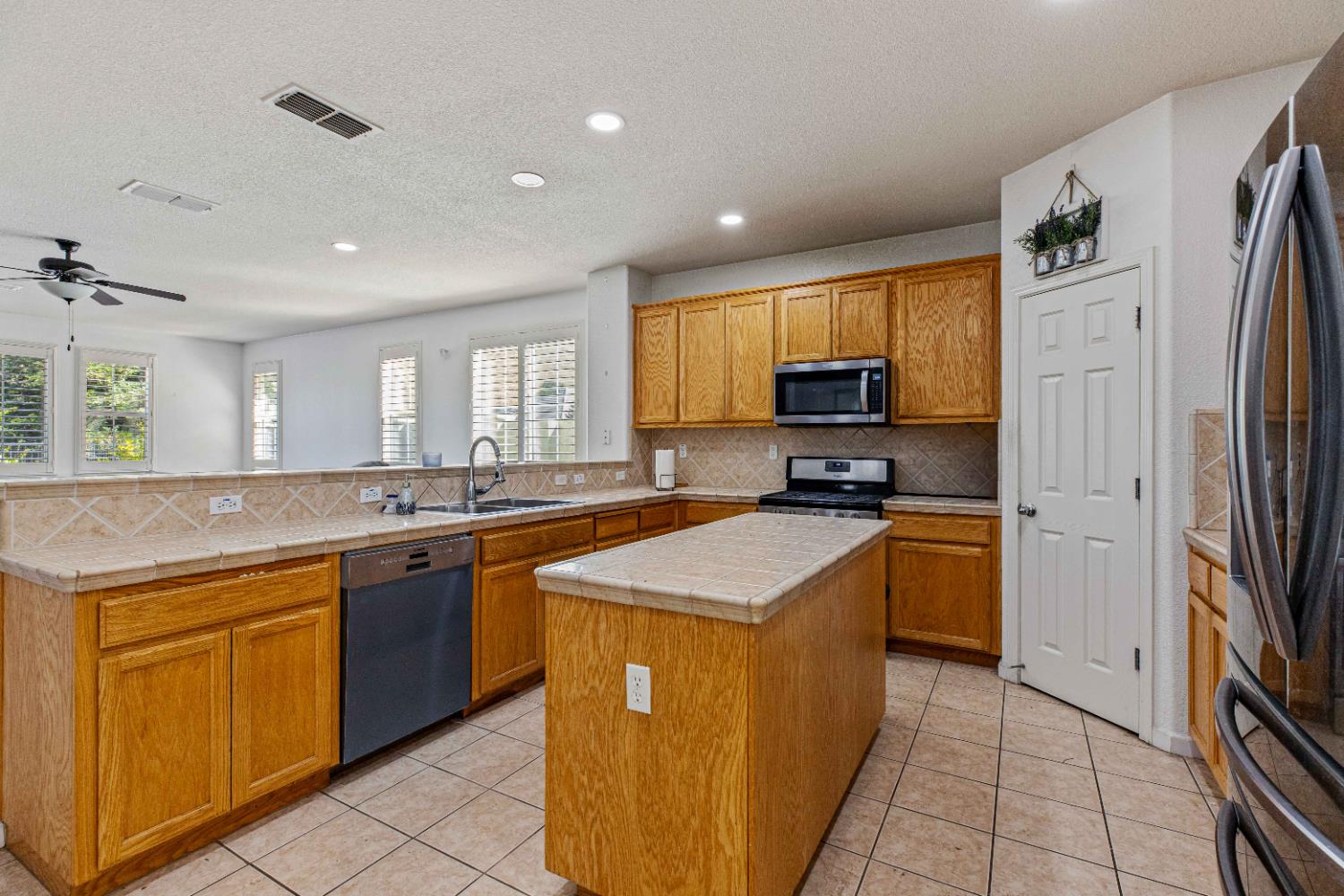 9015 Tee Patterson, CA 95363 - Photo 6 of 36 a kitchen with stainless steel appliances granite countertop a stove top oven a sink and dishwasher