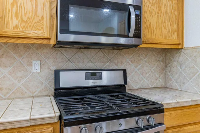 a stove top oven sitting inside of a kitchen