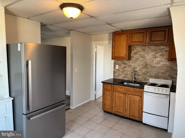 a kitchen with stainless steel appliances granite countertop a refrigerator and a stove