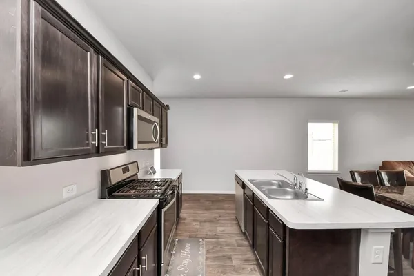 a kitchen with stainless steel appliances a sink stove and refrigerator