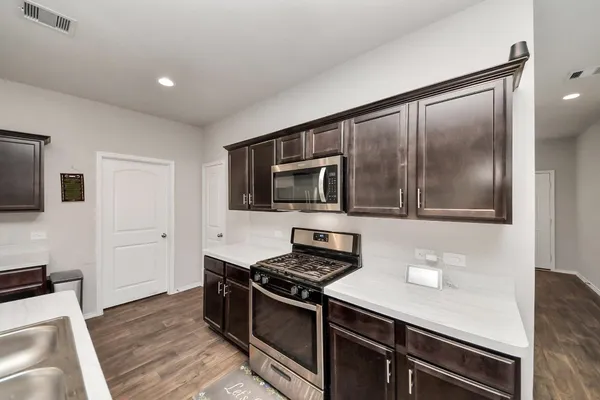 a kitchen with stainless steel appliances a stove microwave and refrigerator