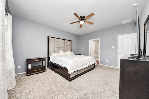 a spacious bedroom with a bed and cabinet