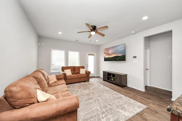 a living room with furniture flat screen tv and wooden floor