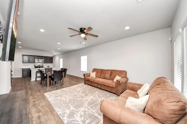 a living room with furniture and a dining table with kitchen view
